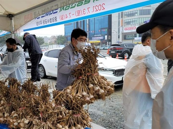  맹정호 서산시장도 판매장을 찾아 힘을 보탰다. 맹 시장이 판매된 마늘을 옮기고 있다.