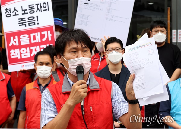 박문순 전국민주일반노동조합 서울본부 법규정책국장이 7일 오후 서울 관악구 서울대학교 행정관 앞에서 열린 ‘서울대학교 청소노동자 사망 관련 오세정 총장 규탄 기자회견’에 참석해 청소노동자를 대상으로 치른 시험지를 공개하며 직장 내 갑질이 자행됐다고 지적하고 있다.