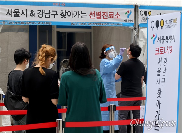 8일 오후 서울 강남역 앞에 설치된 ‘찾아가는 선별진료소’에서 시민들이 신종 코로나바이러스 감염증(코로나19) 검사를 위해 차례를 기다리고 있다.