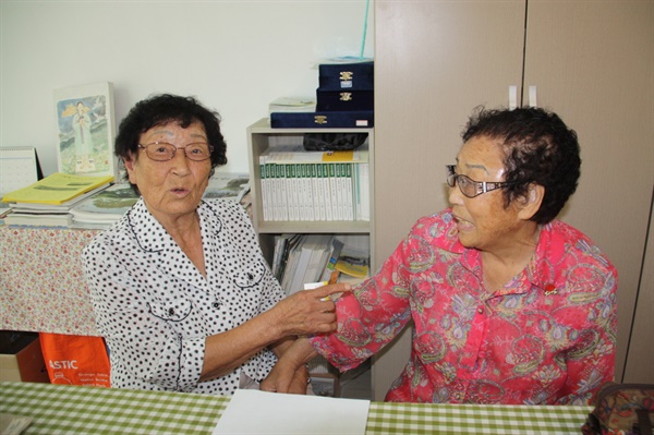 일본에서 돌아온 후 72년 만에 만난 정신영 할머니와 양금덕할머니가 반가워 서로를 가리키며 옛 추억을 꺼내고 있는 모습