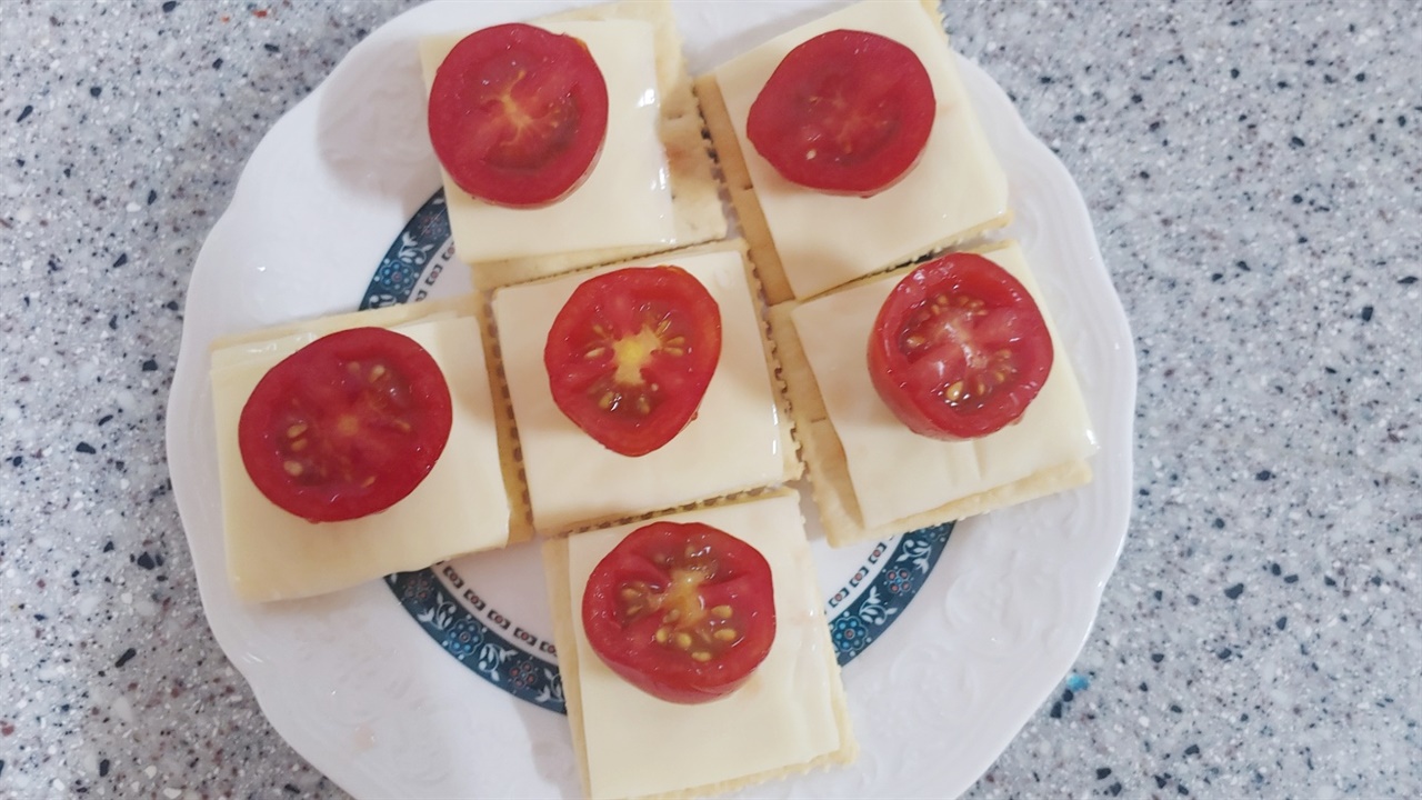 크래커 위에 슬라이드 치즈와 방울토마토를 올렸다. 이렇게 바로 먹어도 맛있다. 