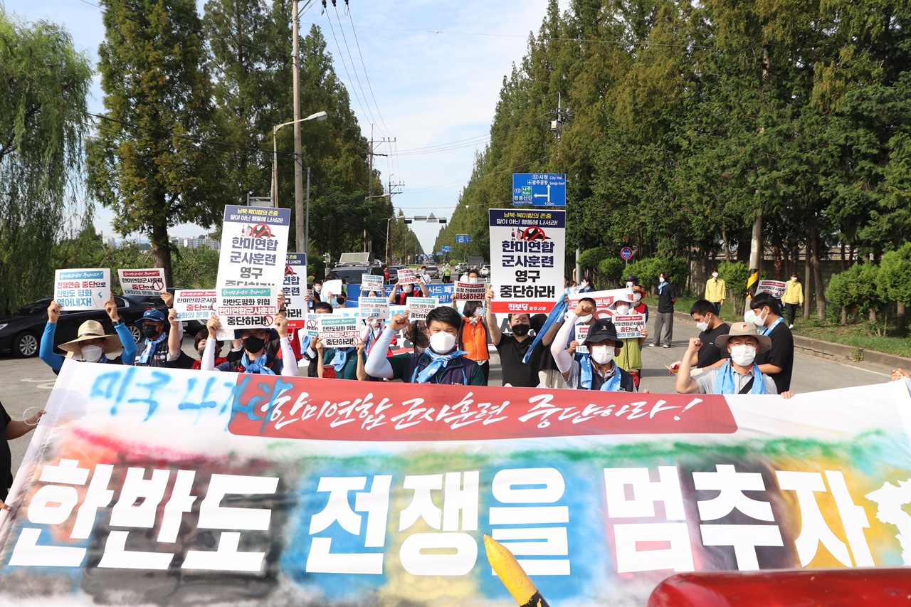 24일 오후, 광주광역시 광산구에 위치한 공군제1전투비행단 정문에서 진행된 한미연합군사훈련 중단과 평화협정 체결을 요구하는 광주지역 1차 공동행동에서 참가자들이 행진을 하고 있다.