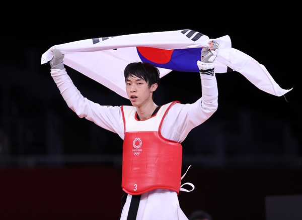  24일 일본 마쿠하리 메세 A홀에서 열린 도쿄올림픽 남자 태권도 58㎏급 경기에서 동메달을 획득한 장준이 태극기를 들고 세리머니를 하고 있다.