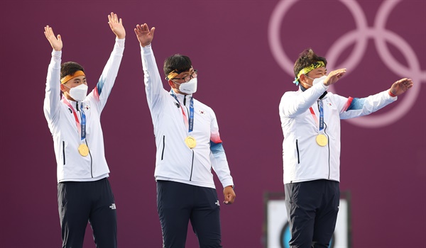 26일 도쿄올림픽 남자 양궁 단체전에서 우승한 김제덕(왼쪽부터), 김우진, 오진혁이 일본 유메노시마 공원 양궁장 시상대에서 응원석을 향해 손을 흔들고 있다.