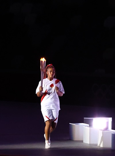 23일 일본 도쿄 신주쿠 국립경기장에서 열린 2020 도쿄올림픽 개막식에서 성화 최종주자 오사카 나오미가 어린이 선수들로부터 성화를 전달받고 성화대로 달리고 있다. 
