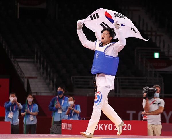  27일 일본 마쿠하리 메세홀에서 열린 도쿄올림픽 남자 태권도 80㎏ 초과급 동메달 결정전 한국 인교돈-슬로베니아 트라이코비치. 인교돈이 승리 후 태극기를 흔들고 있다.