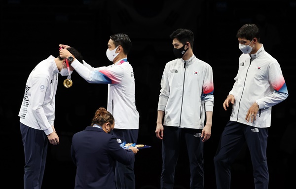 28일 일본 지바의 마쿠하리 메세에서 열린 도쿄올림픽 남자 펜싱 사브르 단체전 대한민국 대 이탈리아 결승전. 한국 선수들이 우승한 뒤 시상대에서 서로 금메달을 걸어주고 있다..