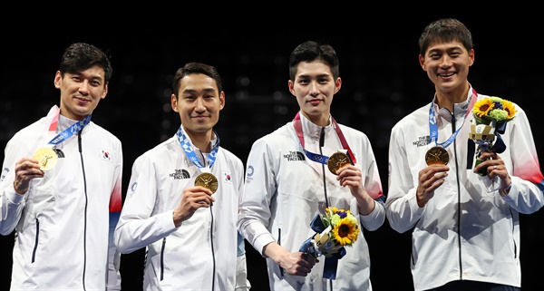  구본길, 김정환, 김준호, 오상욱이 28일 일본 지바의 마쿠하리 메세에서 열린 도쿄올림픽 남자 펜싱 사브르 단체전 시상식에서 금메달을 목에 걸고 기뻐하고 있다. 
