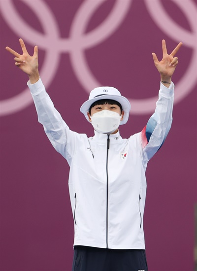 안산이 30일 일본 유메노시마 공원 양궁장에서 열린 도쿄올림픽 양궁 여자 개인전 결승에서 러시아올림픽위원회의 옐레나 오시포바를 상대로 슛 오프 끝에 금메달을 차지한 뒤 시상대에 오르며 양손으로 각각 손가락 세 개를 표시하고 있다.