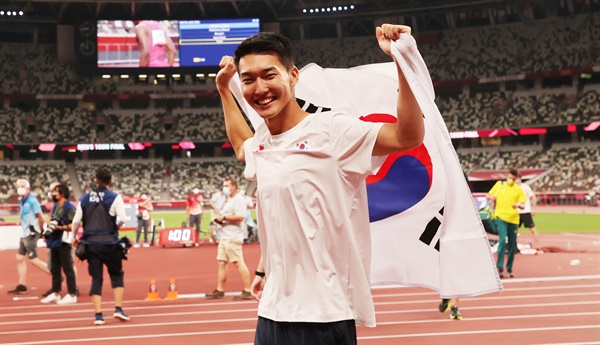 1일 도쿄올림픽 남자 높이뛰기에서 2m 35 한국신기록을 세우며 4위를 차지한 우상혁이 도쿄 올림픽스타디움에서 경기 종료 후 태극기를 펼치며 기뻐하고 있다. 2021.8.1