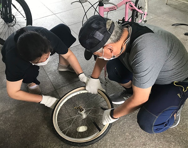  부부가 함께 나와 자전거 기초 수리 교육을 받는 모습