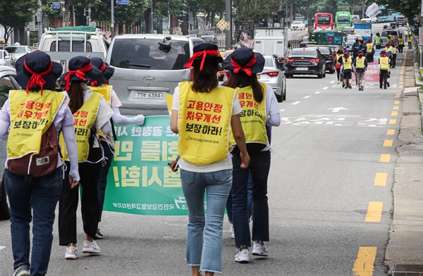  지난달 8일 오전 서울 마포구 애오개역에서 민주노총 공공운수노조 건강보험공단 고객센터지부 13개 단체 관계자들이 건보공단의 '직접 고용'과 '정규직 전환 약속 이행'을 촉구하는 행진을 하고 있다. 행진 참가자들은 코로나19 방역수칙 준수를 위해 최소 허용 인원수인 9명 이하로 만들어 '거리두기' 행진을 했다.