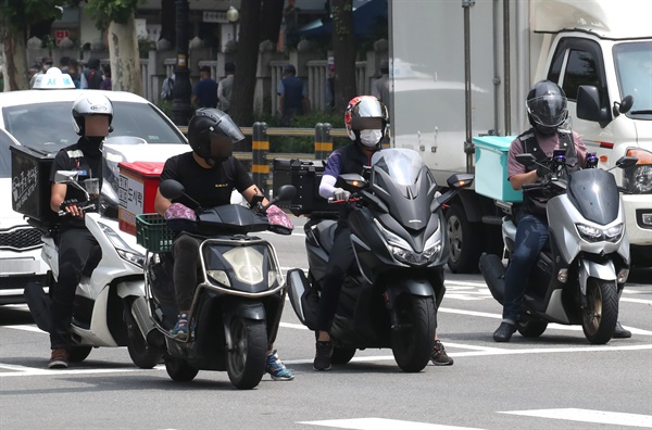 수도권 사회적 거리두기 4단계가 시행된 지난달 12일 오후 배달 오토바이 기사들이 점심 식사를 배달하기 위해 분주히 도심을 누비고 있다.