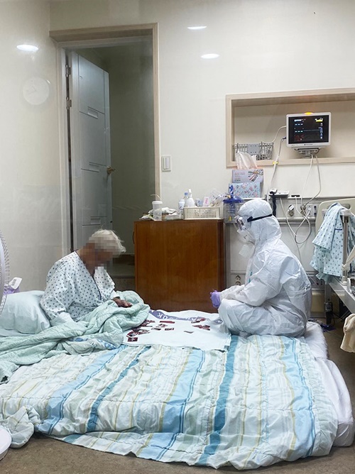 삼육서울병원 간호사들이 음압병동에 홀로 격리된 90대 치매 코로나 확진 할머니를 위해 방호복을 입은 채 화투로 그림 맞추기 하는 모습.