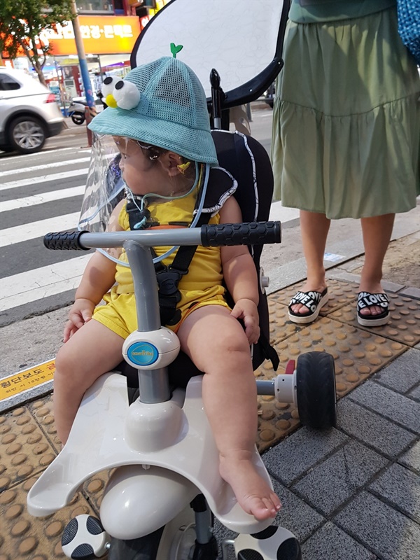 자전거형 유모차와 일명 '코로나 모자'를 쓴 아기