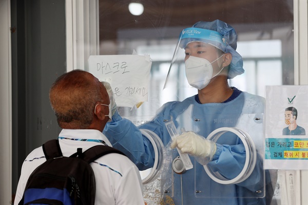 코로나19 신규확진자가 1700명 대를 기록한 8일 오전 서울역에 마련된 코로나19 임시선별검사소에서 의료진이 검체채취를 하고 있다. 