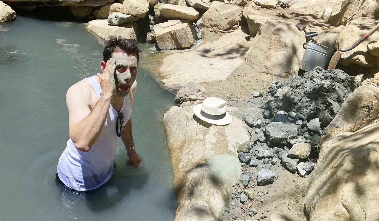  온천욕을 하러온 남성이 녹색 진흙을 얼굴에 바르고 있다. 돌멩이를 갈아서 녹색 진흙팩을 만들었다.