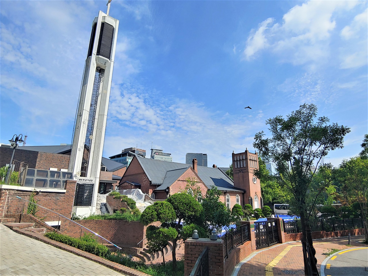 100주년 기념탑과 1897년 지어진 교회가 같이 보인다. 교회 경역은 많은 건축물들로 빼곡하다.