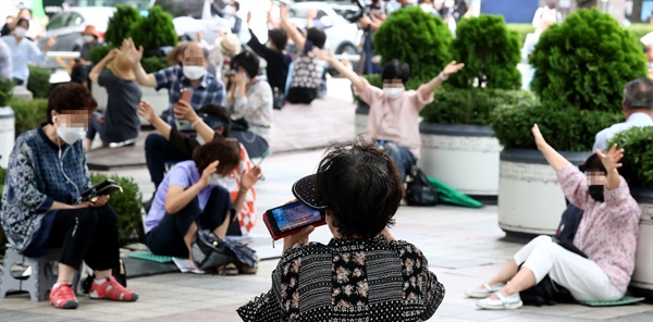 관할 구청으로부터 시설 폐쇄 결정을 받은 서울 성북구 사랑제일교회 신자들이 22일 서울 광화문 동화면세점 앞에서 현장 예배를 하고 있다.