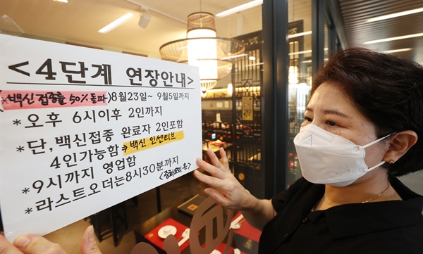 22일 서울 양천구 한 중식당에서 관계자가 '백신 인센티브' 안내문을 붙이고 있다.