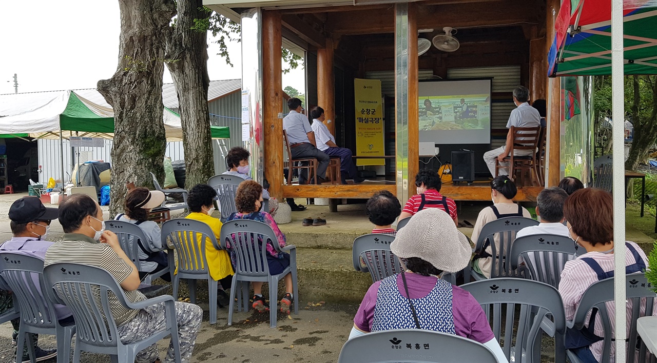 주민들이 마을 모정에 모여 영화 '장수상회'를 관람했다.
