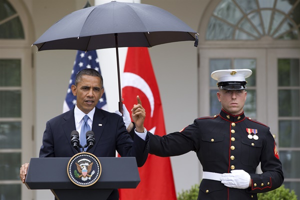 2013년 5월 16일 버락 오바마 미국 대통령이 백악관 로즈가든에서 열린 레제프 타이이프 에르도안 터키 총리와 공동 기자회견에서 발언하는 도중 비가 내리자 해병대원이 우산을 들고 있다. 