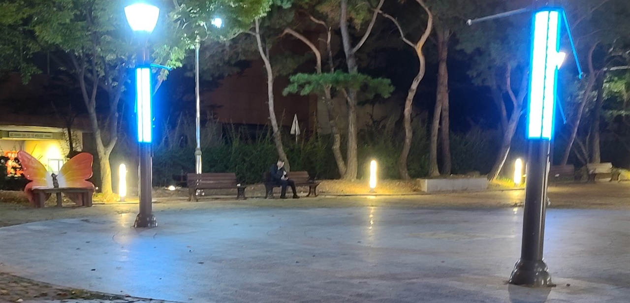 한 대리기사가 아무도 없는 공원에서 콜을 기다리고 있다