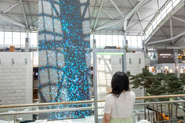 인천국제공항을 찾은 한 관광객이 '미디어아트 센싱프레임'을 실제로 체험해보고 있다.