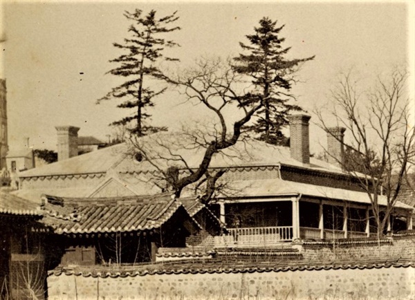 1899년 3월 아펜젤러가 촬영한 사진. 베란다가 있는 넓은 4각 평면에 1.5층으로 추정되는 지붕 속 공간이 굴뚝 아래 보인다. 독립신문 기사에 "존 헨리 다이가 2층으로 설계하였다"고 소개된 이유로 추정된다. 
