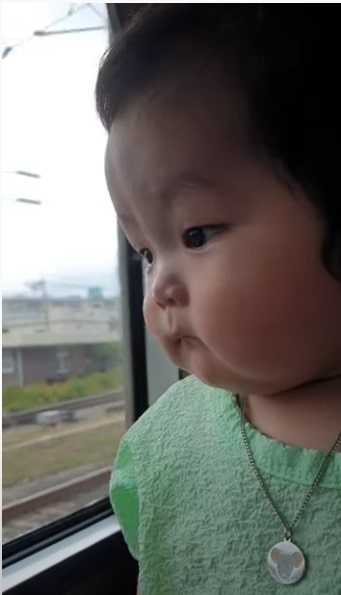 차창 밖을 보고 있는 아기, 아기의 눈빛이 여행에 진심임을 말하고 있다. 