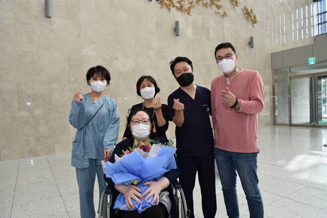 10일 코로나19로 혼수상태에 빠졌던 이 씨(앞줄)가 성남시의료원에서 에코모 치료 통해 건강하게 퇴원하며 의료진들과 기념사진을 찍고 있다. 