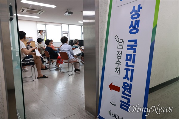 '코로나 상생 국민지원금' 현장접수 첫날인 13일 오전 서울 성북구 길음1동 주민센터 3층에 마련된 접수창구에 신청서를 든 시민들이 대기하고 있다.