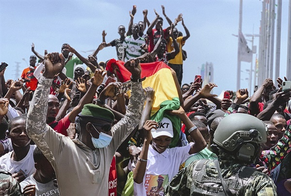 2021년 9월 5일 기니에서 쿠데타가 벌어졌다. 다음날인 6일 기니 코나크리에 있는 인민궁전 앞에서 기념행사가 진행되는 동안 기니 국민들이 국기를 흔들며 축하하고 있는 모습. 