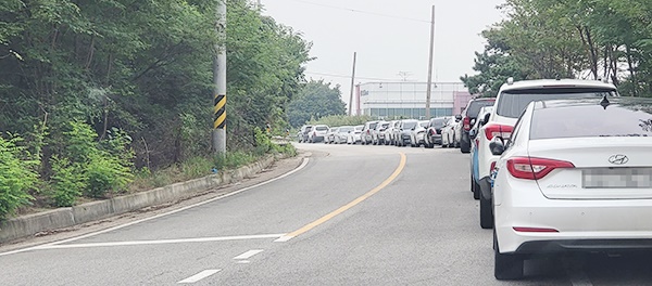 주변도로는 직원들이 타고 다니는 차량 수십대가 줄지어 서 있다.    					  