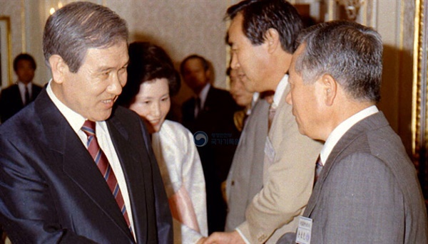  1989년 해외에서 개최된 국제영화제 수상자들을 격려하는 노태우 대통령이 김동호 당시 영화진흥공사 사장과 악수하고 있다. 