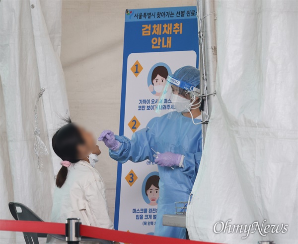 29일 오후 서울 송파구 가락농수산물종합도매시장에 설치된 신종 코로나바이러스 감염증(코로나19) 임시선별진료소에서 시민이 검체 검사를 받고 있다. 