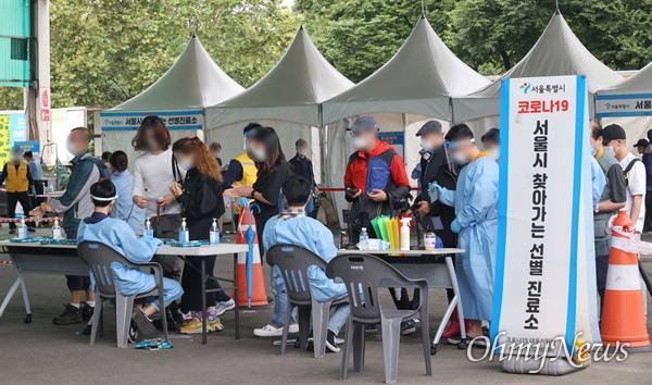 지난 9월 29일 오후 서울 송파구 가락농수산물종합도매시장에 설치된 신종 코로나바이러스 감염증(코로나19) 임시선별진료소에서 시장 상인과 시민들이 검체 검사를 받기 위해 줄을 서서 기다리고 있다.