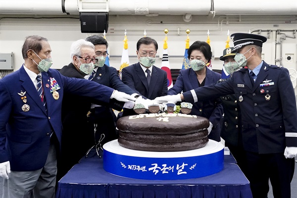 문재인 대통령과 김정숙 여사가 1일 경북 포항 영일만 해상 마라도함 격납고에서 열린 제73주년 국군의날 기념 다과회에서 참석자들과 기념케이크를 자르고 있다. 왼쪽부터 김진호 재향군인회장, 해병 1기 이봉식 옹, 서욱 국방부장관, 문 대통령, 김 여사, 허윤영 육군 대위, 조주영 공군 중령(진).