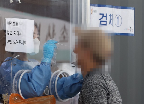 5일 오전 서울역광장에 마련된 신종 코로나바이러스 감염증(코로나19) 임시 선별검사소에서 의료진이 검체를 채취하고 있다. 중앙방역대책본부(방대본)는 이날 0시 기준으로 신규 확진자가 1천575명 늘어 누적 32만1352명이라고 밝혔다.