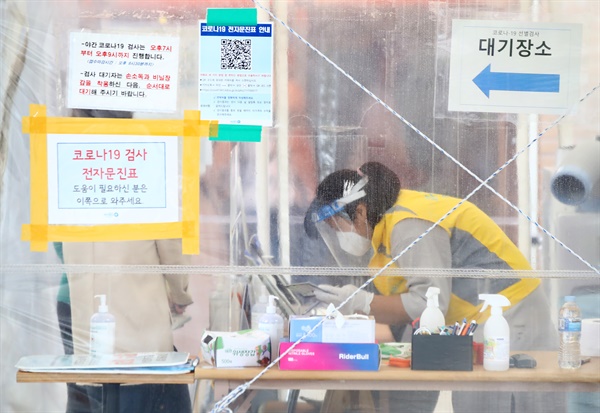 지난 10일 오전 코로나19 집단감염으로 폐쇄된 서울 마포농수산물시장 인근에 있는 서울 마포구보건소 코로나19 선별진료소에서 한 관계자가 시민들이 작성한 문진표를 확인하고 있다.