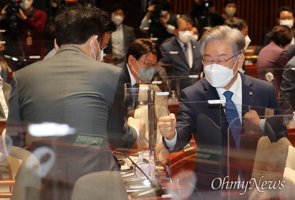 이재명 대선 후보가 15일 오전 서울 여의도 국회 예결위회의장에서 열린 더불어민주당 의원총회에 참석하며 의원들과 인사를 나누고 있다.