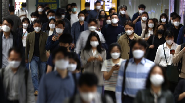 정부가 오는 18일부터 적용될 새로운 방역지침을 발표한 15일 오전 서울 지하철 광화문역에서 직장인 등 시민들이 걸어가고 있다.