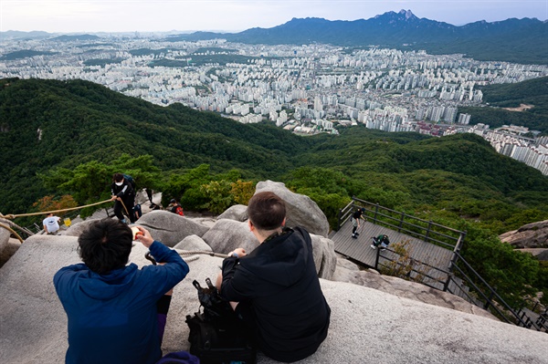 휴일을 맞아 불암산 정상에 오른 사람들이 서울 시내를 내라보고 있다.