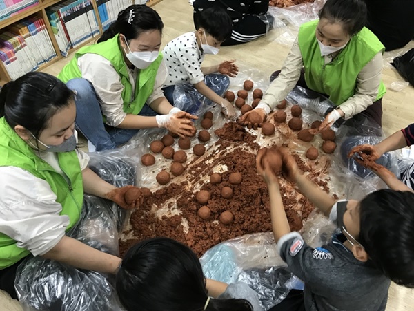 동천동자원봉사캠프 회원들이 광주천 수질 개선을 위해 황토에 EM발효액을 섞어 반죽하고 있다