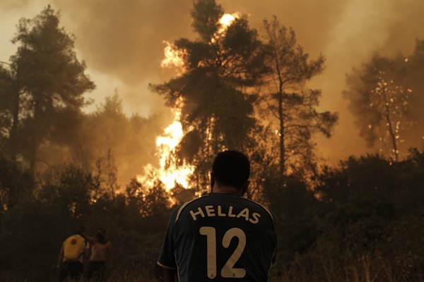 지난 8월 8일 그리스 에비아섬에서 발생한 대형 산불을 한 주민이 망연자실한 듯 바라보고 있다.
