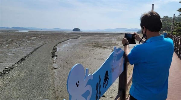 한 시민이 바닷길을 카메라에 담고 있다. 섬의 모양이 곰의 형상을 닮았다고 해서 붙여진 '웅도'는 세계 5대 갯벌인 가로림만 내에 있는 섬이다.
