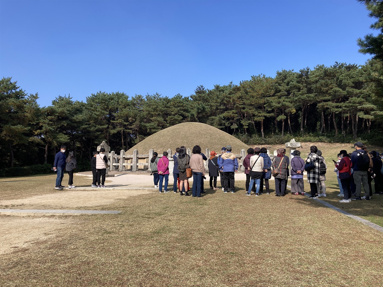 김유신묘 앞에서 문화관광해설사의 해설을 듣고 있는 관광객 모습