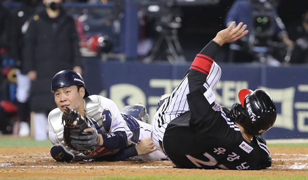  5일 서울 송파구 잠실야구장에서 열린 2021 프로야구 KBO 포스트시즌 준플레이오프 2차전 두산 베어스와 LG 트윈스의 경기. LG의 4회초 2사 주자 1 ,3루에서 2루 주자 유강남이 동료 김민성의 안타를 틈타 홈으로 쇄도하자 두산 포수 박세혁이 태그를 시도하고 있다. 