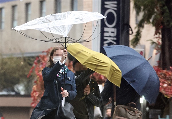강풍으로 시민이 든 우산이 뒤집어지고 있다. 자료사진.