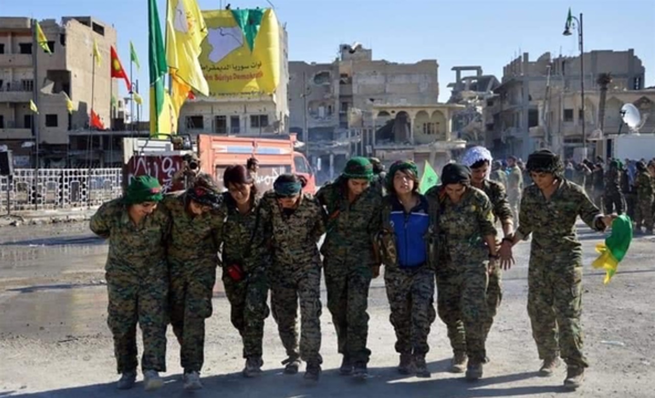  IS가 점령했던 도시를 되찾은 YPJ 여전사들이 광장에 YPJ, YPG, 쿠르디스탄 깃발을 걸어 놓고 전통 춤을 추며 기뻐하고 있다. 